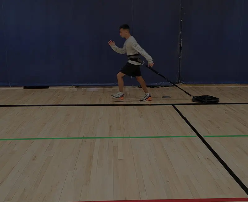 Person lunging forward in a gymnasium.