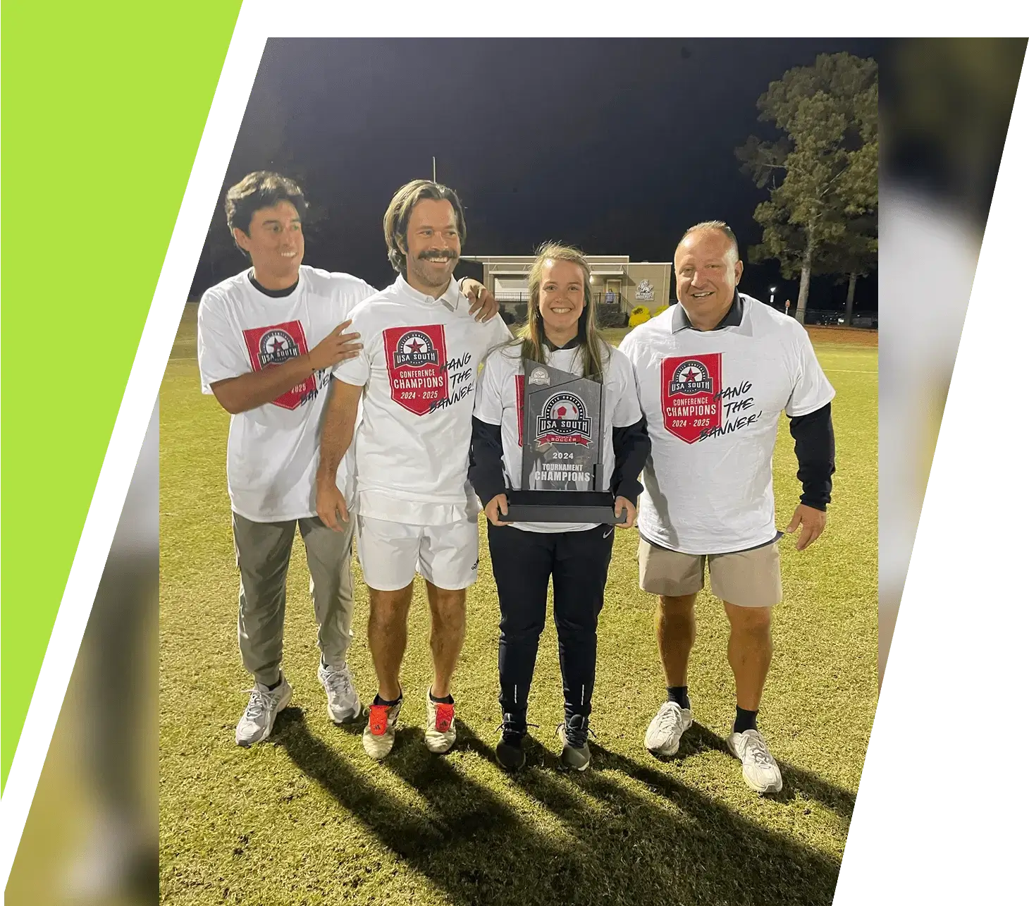 Four men in matching white shirts pose on a grassy field at night.
